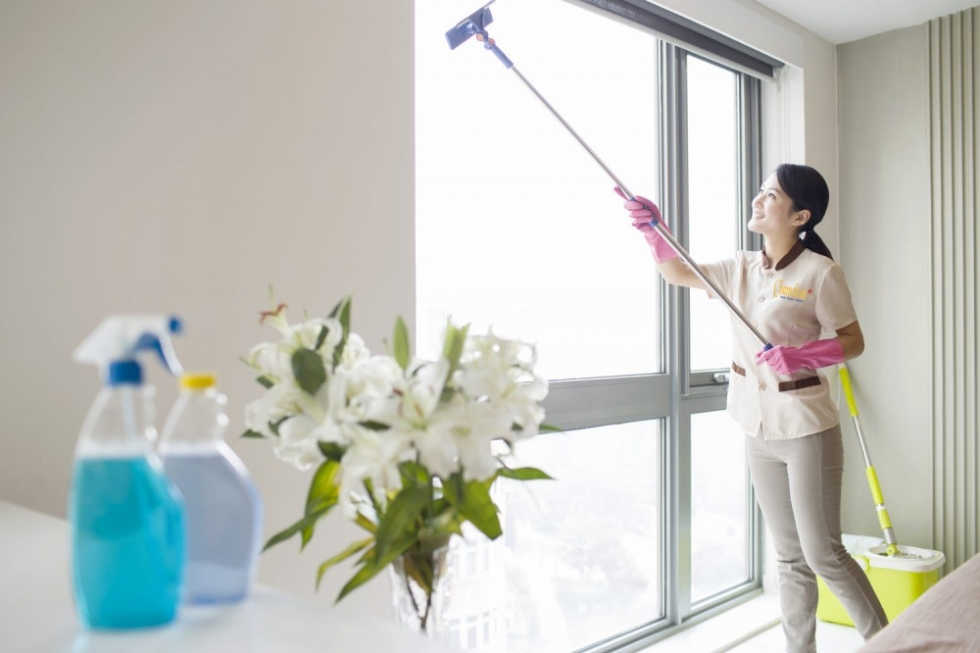 nhân viên đang vệ sinh cửa kính