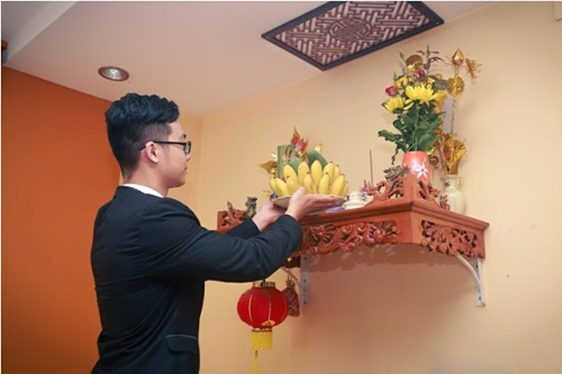 Chủ nhà ăn mặc lịch sự để tiến hành các nghi lễ cúng dọn về nhà mới